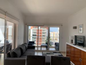a living room with a couch and a television at ConVistaApartment with Pool in Portimão