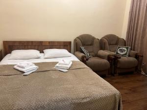 Adamyan 11 hotel في يريفان: غرفة نوم بسرير وكرسيين