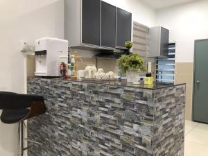 a kitchen with a stone counter top in a room at Baituljannah Homestay Batu Pahat in Batu Pahat