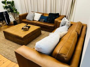 een woonkamer met twee bruine banken en een tafel bij Beautiful Villa - Scottburgh, Durban in Scottburgh