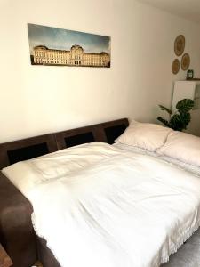 - un lit blanc dans une chambre avec une photo sur le mur dans l'établissement Urban Retreat - Central and Historic with Private Parking, à Wurtzbourg