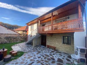 een huis met een balkon en een patio bij Casa Cireșu in Cireşu