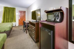 a hotel room with a tv and a desk with a computer at Quality Inn Fort Campbell-Oak Grove in Oak Grove