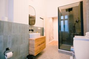 een badkamer met wastafel en douche met spiegel bij The Weinert Suites in Berlijn +34 foto's