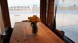 オーステンデにあるSan Marcoの窓付きの木製テーブルに花瓶