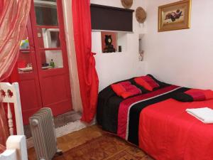 a bedroom with a bed and a red door at AL-Pinheiro 62 in Porto
