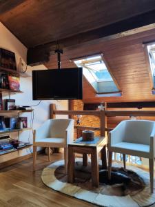 a living room with two chairs and a table and a tv at Luxury Hotel Apartment - Jahorina in Jahorina