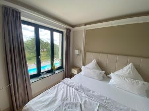 a bedroom with a bed and a large window at Avella "Sundowner" mit Meerblick, Innenpool und eigener Wallbox in Binz