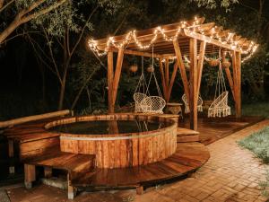 a wooden pergola with a hot tub in a backyard at Pensiunea Meander in Gherla