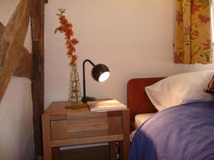 ein Schlafzimmer mit einem Bett und einem Tisch mit einer Lampe in der Unterkunft Wyre Forest Cottage in Bewdley