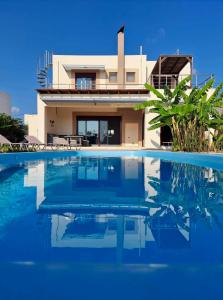 a house with a swimming pool in front of a house at Villa Chrysa Rhodes in Afantou