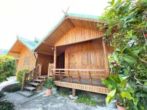 a small wooden house with a porch and stairs at จันทวี รีสอร์ท in Changwat Prachuap Khiri Khan