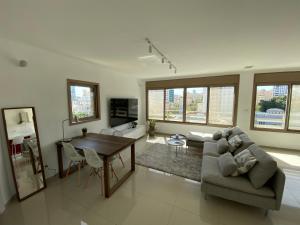 uma sala de estar com um sofá e uma mesa em Vibe Place em Netanya