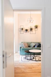 a living room with a blue couch and a table at The Weinert Suites in Berlin