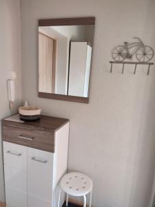 a bathroom with a dresser and a mirror and a stool at Apartament Olivia Centrum z zamknietym parkingiem in Gdańsk