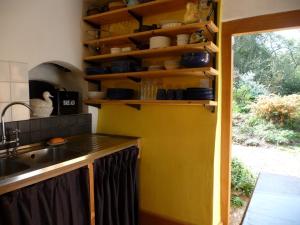 a kitchen with a sink and a yellow wall at Wyre Forest Cottage in Bewdley