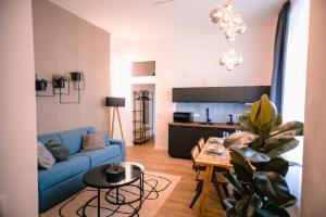 een woonkamer met een blauwe bank en een tafel bij The Weinert Suites in Berlijn