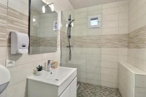 a white bathroom with a sink and a shower at Chambre cosy jo in Saint-Alban