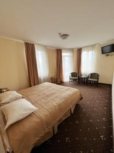 a hotel room with a large bed and windows at Hotel Zorepad in Zabolotiv
