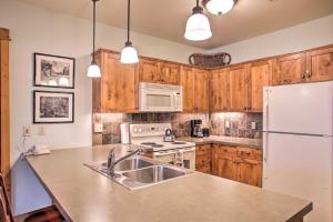 a kitchen with a sink and a white refrigerator at Cozy Kellogg Condo - Ski at Silver Mountain Resort in Kellogg