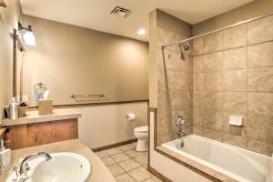 a bathroom with a tub and a toilet and a sink at Cozy Kellogg Condo - Ski at Silver Mountain Resort in Kellogg