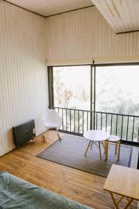 Habitación con balcón con mesa y sillas. en Milodge Elqui Domos en Pisco Elqui