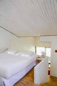 Schlafzimmer mit einem großen weißen Bett und einem Schreibtisch in der Unterkunft Milodge Elqui Domos in Pisco Elqui