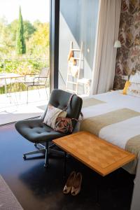 a hotel room with a chair and a bed and a balcony at Maison Jalon in Aix-en-Provence