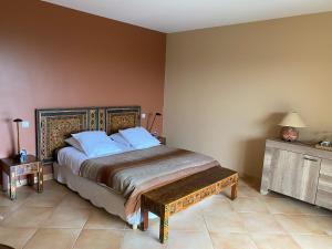 1 dormitorio con 1 cama grande y cabecero de madera en La Mauresque en Grimaud