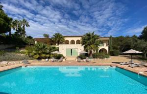 a large swimming pool in front of a house at La Mauresque in Grimaud