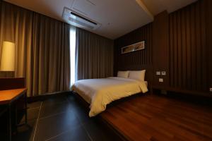 a hotel room with a bed and a window at Sejong City Osong Hotel in Cheongju