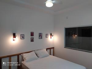 1 dormitorio con 1 cama y TV de pantalla plana en Casa próxima do mar com piscina privativa, en Prado