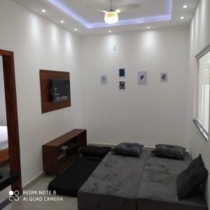 1 dormitorio con 1 cama y TV en la pared en Casa próxima do mar com piscina privativa, en Prado