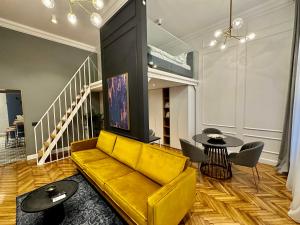 a living room with a yellow couch and a table at Olimpia Residence Palace Oradea in Oradea