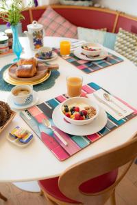 a table with a breakfast of cereal and fruit at Maison Jalon in Aix-en-Provence