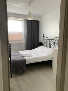- une chambre avec un lit doté de draps blancs et une fenêtre dans l'établissement Apartament Żeromskiego, à Biała Podlaska