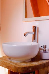 a white bowl sink on a wooden counter with a mirror at Milodge Elqui Domos in Pisco Elqui