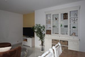 a living room with a large white cabinet with a tv at Lilli`s Ferienwohnung in Sinsheim