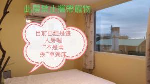 una ventana con una señal de nube en un dormitorio en 貓居 ocean house en Dahan