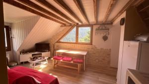 an attic room with a table and a window at Appartement Chalet Pra Loup in Uvernet