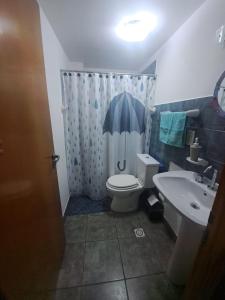 a bathroom with a toilet and a sink at Departamentos Buen Pasar in Ushuaia