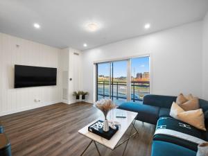 奧克維爾的住宿－Stylish 3Br + Study Condo - Oakville，客厅配有蓝色的沙发和电视