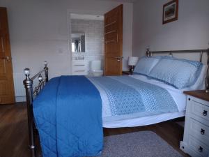 a bedroom with a bed with a blue comforter at Park Avenue in Newcastle