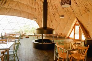a restaurant with a fireplace in the middle of a room at Milodge Elqui Domos in Pisco Elqui
