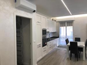 een keuken met witte kasten en een tafel met stoelen bij WHITE HOUSE in Verona