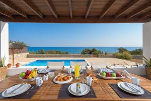 a table with food and a view of the ocean at Villa Corinna in Lakhania