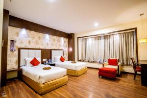 a hotel room with two beds and a chair at Holiday Home Ranchi in Rānchī +36 photos