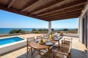 a patio with a table and chairs and a swimming pool at Villa Corinna in Lachania