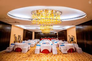 a banquet hall with white tables and a chandelier at Holiday Home Ranchi in Rānchī