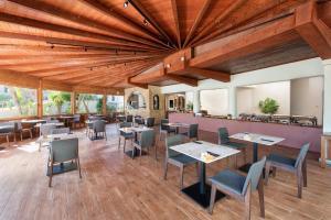 イクシアにあるIxia Dream hotel - Adults onlyの木製の天井、テーブルと椅子のあるレストラン